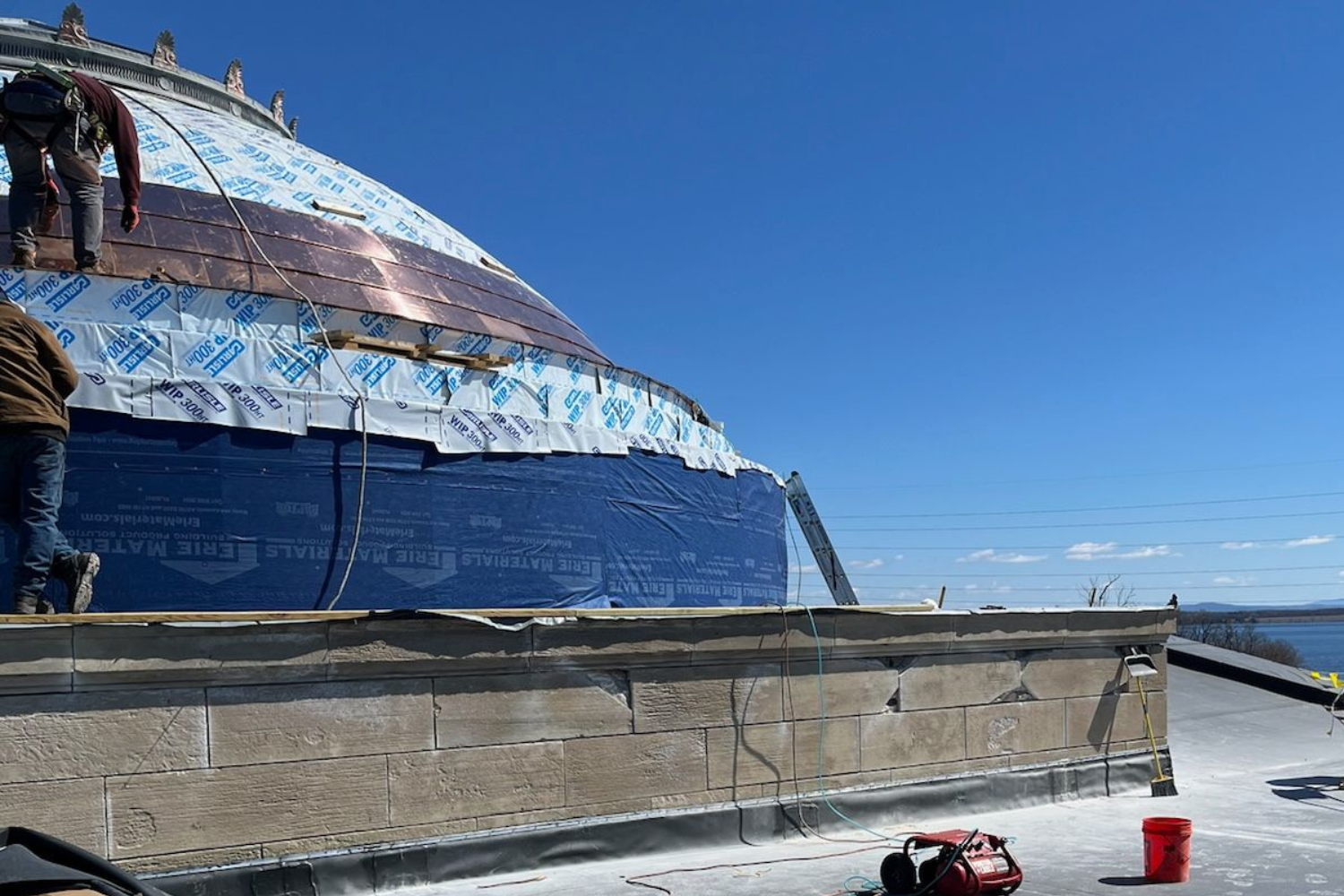 The dome on the roof of Plattsburgh City Hall renovation in progress, with three rows of copper already affixed.